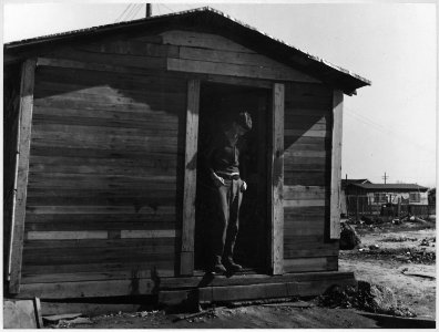 Sunset District, Kern County, California. Young man (white) in the doorway of his home which is loca . . . - NARA - 521806 photo