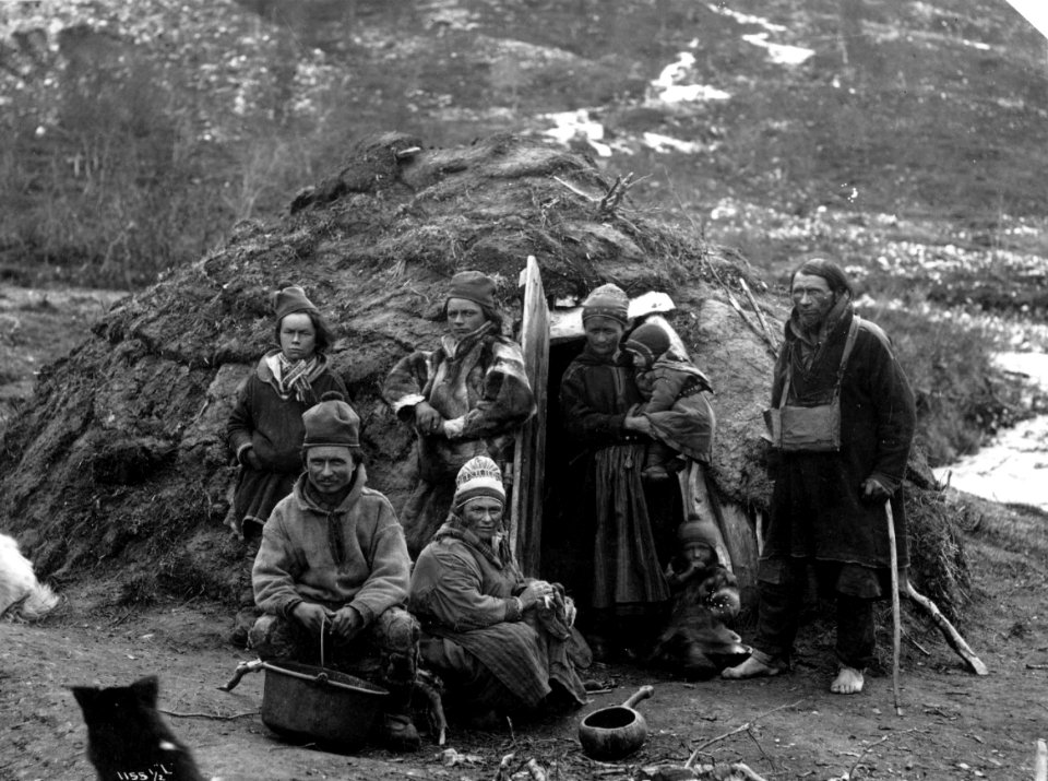 Svenske samer, muligens fra Karesuando, foran en gamme. Antagelig Lyngen 1885-1892 - Norsk folkemuseum - NF.06789-017