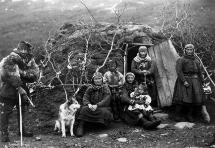 Svenske samer og en hund utenfor døråpningen til en gamme, fem voksne og to barn. Nord-Norge 1906 - Norsk folkemuseum - NF.06789-030