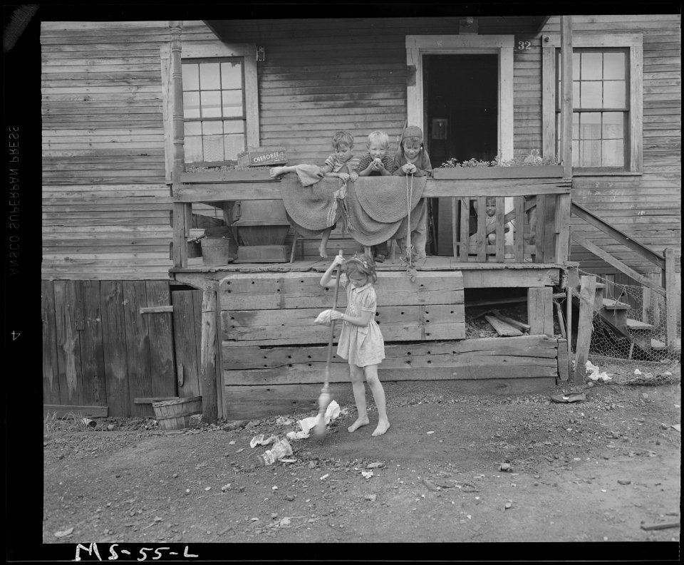 Sweeping up debris in front of company house. Coal bin is under front porch. Louise Coal Company, Louise Mine, Case... - NARA - 540247