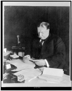 Taft, President reading at desk in White House LCCN96511571