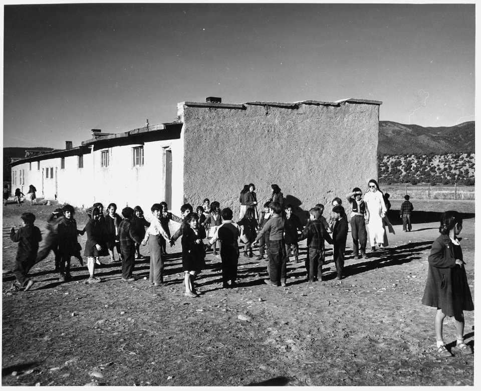 Taos County, New Mexico. Children play in the Penasco schoolyard. School was built by the Catholic . . . - NARA - 521831