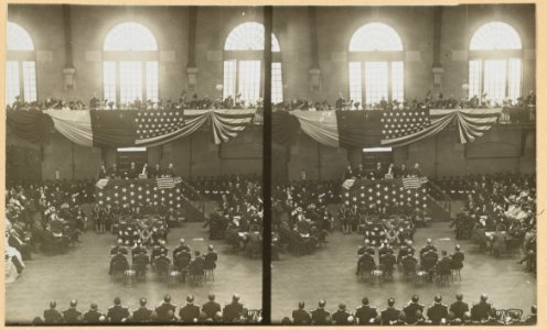Teddy Roosevelt on a flag-draped platform, speaking to a group of people LCCN2009633761