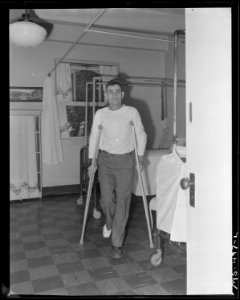 Telesfro Deluna, miner, walking on crutches. He is recovering from foot injured in mine accident. He has received... - NARA - 540448 photo