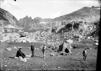 Tenda i caçadors en un campament de caça amb el Malh de Pois al fons