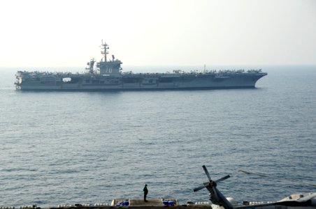 The aircraft carrier USS Carl Vinson (CVN 70), background, relieves the aircraft carrier USS George H.W. Bush (CVN 77) in the Persian Gulf Oct. 18, 2014, during Inherent Resolve 141018-N-MU440-027