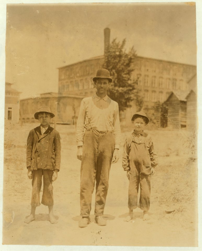 The Norton boys and father on the way home to dinner. Smallest boy Edgar been sweeping 3 months in Saxon Mill, Spartanberg. Makes about 40 cents a day. His brother makes 60 cents. Father LOC nclc.02563