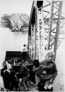 The old and the young flee Tet offensive fighting in Hue, managing to reach the south shore of the Perfume River despite - NARA - 541870
