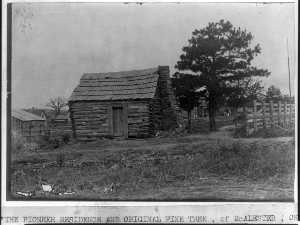 The Pioneer residence and original pine tree of McAlester, Okla., old log cabin in foreground LCCN2006683532