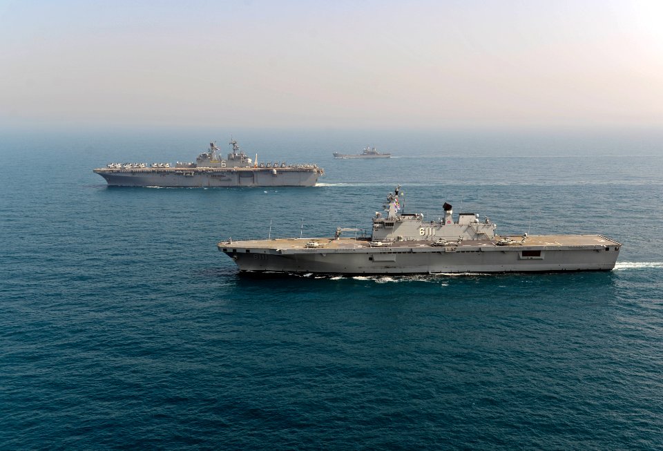 The South Korean amphibious assault ship ROKS Dokdo (LPH 6111), front, transits alongside the amphibious assault ship USS Bonhomme Richard (LHD 6) during a photo exercise with other ships assigned to 140327-N-BJ178-495
