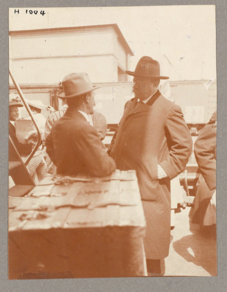 Theodore Roosevelt conversing with a man on deck of ship. Passengers in background LCCN2013650590