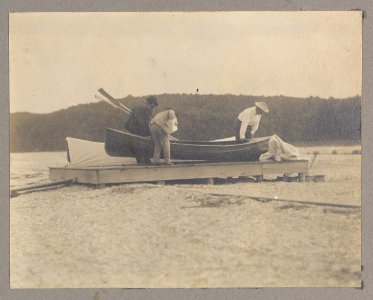 Theodore Roosevelt and two other men on a dock with a canoe LCCN2013651253