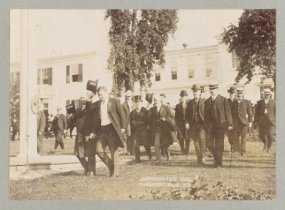 Theodore Roosevelt and a group of men walking across a lawn LCCN2013651080