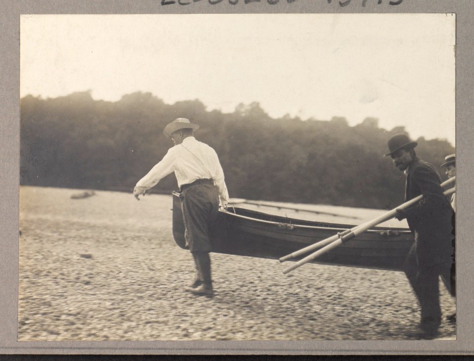 Theodore Roosevelt and another man carrying a canoe as a third man carries the oars LCCN93511340