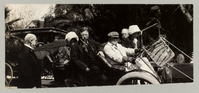 Theodore Roosevelt and others disembarking from an open automobile LCCN2002723162
