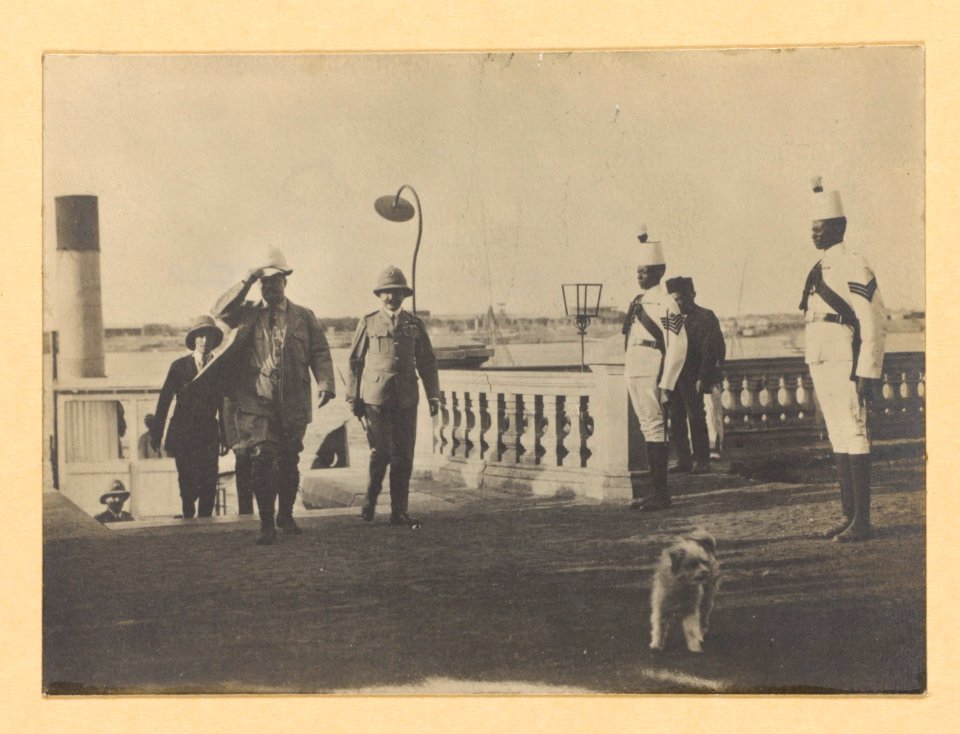 Theodore Roosevelt and others, walking away from stairs in an outdoor area, two guards on right LCCN2002712114