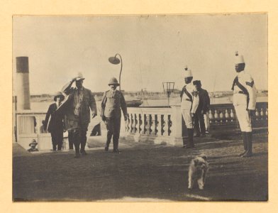Theodore Roosevelt and others, walking away from stairs in an outdoor area, two guards on right LCCN2002712114