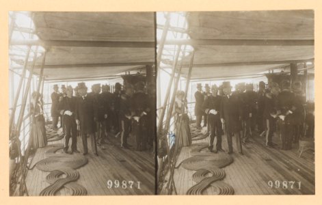 Theodore Roosevelt on deck of ship with group of naval officers. A woman leans against the ship's railings LCCN2013650579