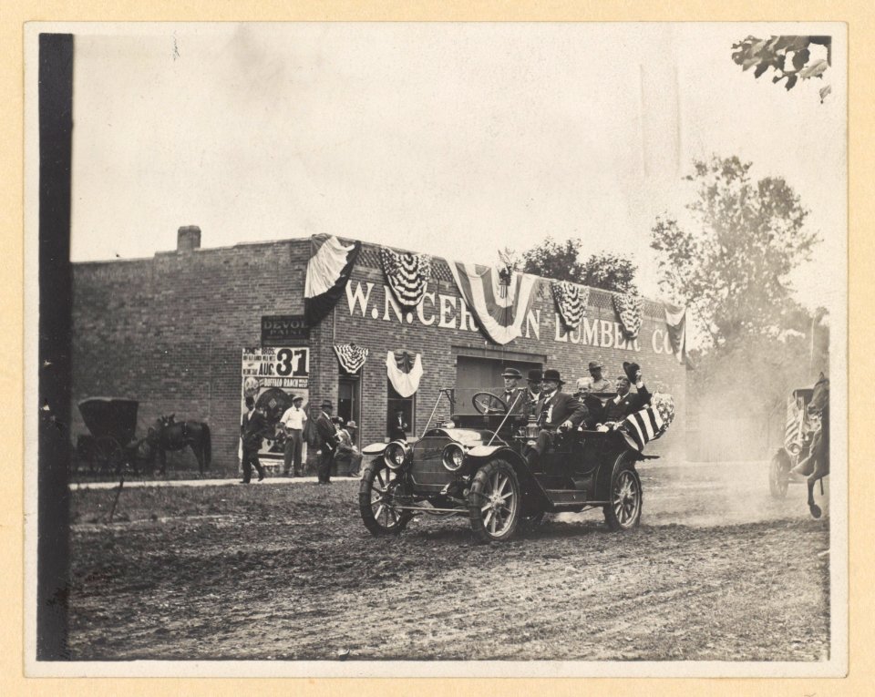 Theodore Roosevelt riding in a convertible, tipping his hat to onlookers LCCN2013651464
