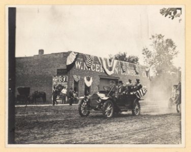 Theodore Roosevelt riding in a convertible, tipping his hat to onlookers LCCN2013651464