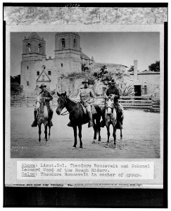 Theodore Roosevelt posed on horseback, in uniform, between two other men also on horseback, in front of church San Antonio, Texas, during the Spanish-American War LCCN00652078