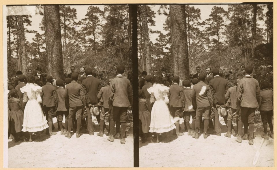 Theodore Roosevelt speaking to a group of African American children on the edge of woods LCCN2009633756