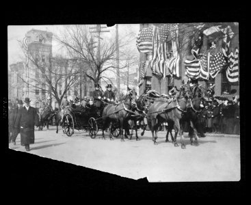 Theodore Roosevelt sitting in an open carriage enroute to the U.S. Capitol on his inauguration day tips his hat to spectators LCCN2004679196