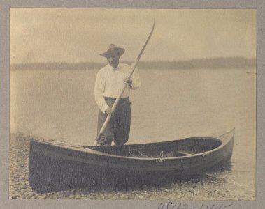Theodore Roosevelt standing with a canoe and holding an oar LCCN2010645462
