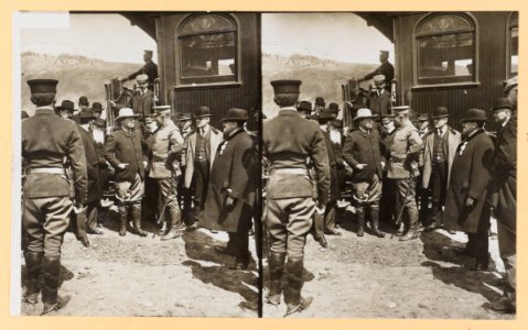 Theodore Roosevelt standing by a railroad car talking with a group of men LCCN2009633771