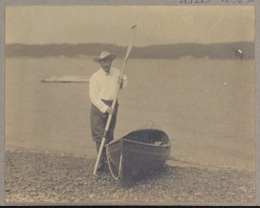Theodore Roosevelt standing with a canoe and holding an oar LCCN2010645463