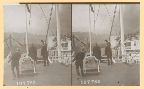 Theodore Roosevelt, and two other men, standing on deck of a ship, with their backs to camera, Roosevelt waving his hat to the crowd on another ship LCCN2013650575