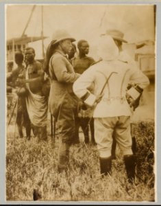 Theodore Roosevelt standing with mostly African men in traditional dress LCCN2010645481