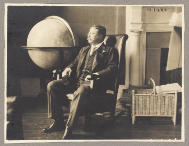 Theodore Roosevelt, full-length portrait, seated by world globe, facing left LCCN96524349