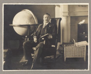 Theodore Roosevelt, full-length portrait, seated next to a globe LCCN2009633122