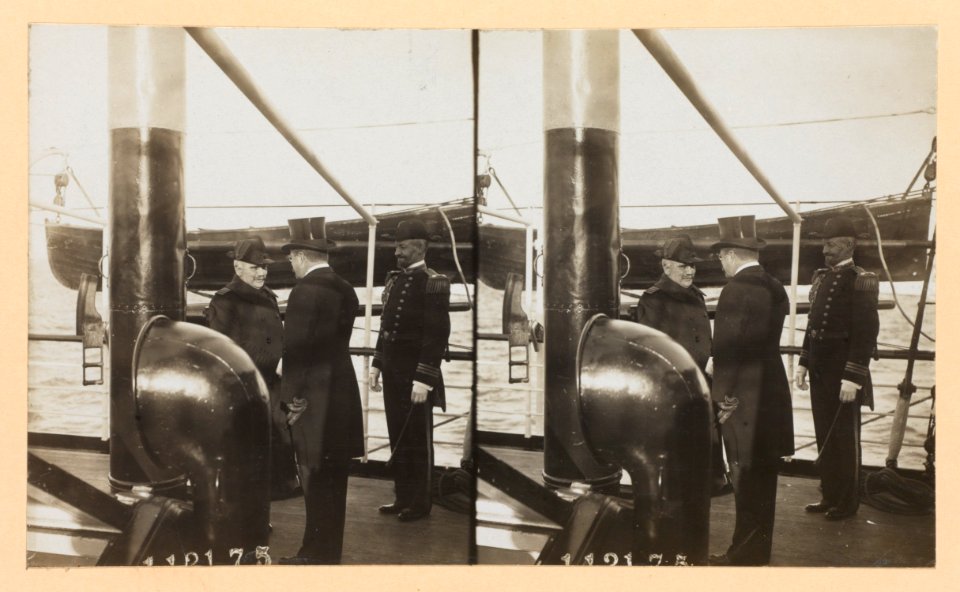 Theodore Roosevelt, back to camera, with two naval officers on deck of ship LCCN2013650582