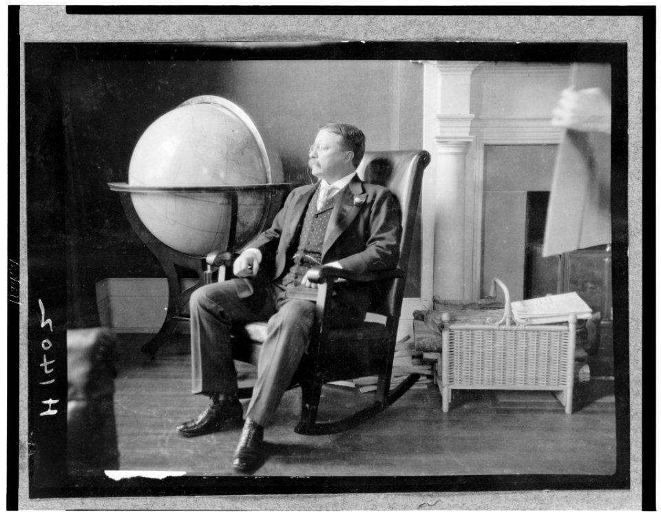 Theodore Roosevelt, full-length portrait, seated in rocking chair, facing left, by large globe LCCN96523633