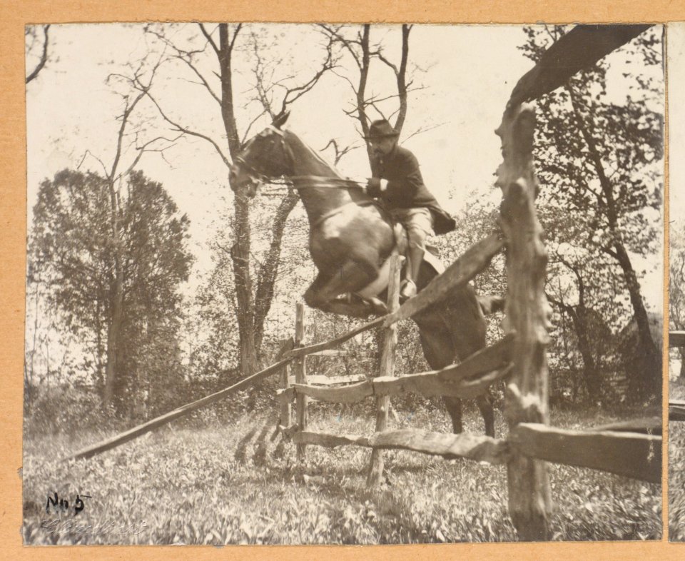 Theodore Roosevelt, on horseback, jumping over a split rail fence LCCN2013651343