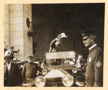 Theodore Roosevelt, standing in open automobile, waving his hat LCCN2009633775