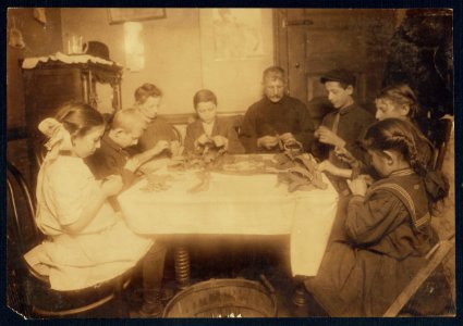 These garters are made for Berger, 92 Spring St. 9-00 P.M., Feb. 27-12. Making garters (armlets). A Jewish family and neighbors working until late at night. This happens several nights in the week when there is LOC nclc.04202