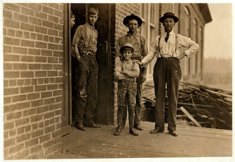 This boy has worked in Payne Cotton Mill, for 2 yrs Macon, Ga. Runs 4 sides and earns 52 cents a day. Overseer has hand on boy' s shoulder. He said this mill made 70% profit last year and LOC cph.3a29770