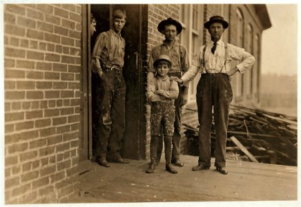 This boy has worked in Payne Cotton Mill, for 2 yrs Macon, Ga. Runs 4 sides and earns 52 cents a day. Overseer has hand on boy' s shoulder. He said this mill made 70% profit last year and LOC cph.3a29770