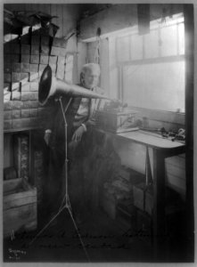 Thomas Alva Edison, full-length portrait, standing, facing right, listening to a new record LCCN96513667