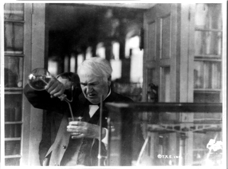Thomas Edison, half-length portrait, facing left and looking down into glass, experimenting in his laboratory LCCN90706082