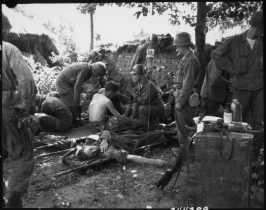 Wounded American soldiers are given medical treatment at a first aid station, somewhere in Korea. - NARA - 531364