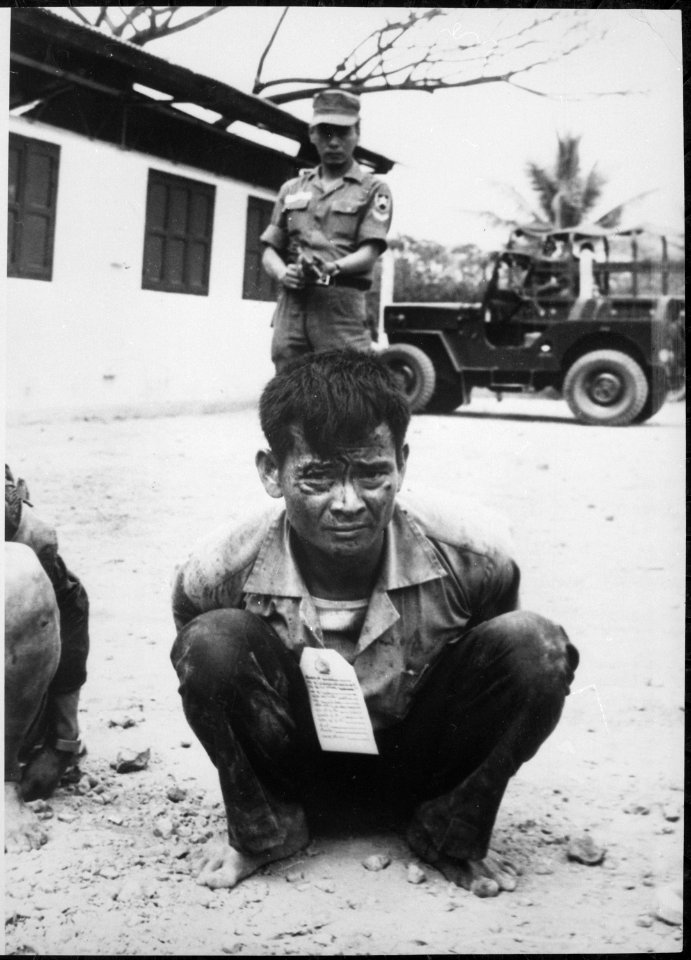 Youthful hard-core Viet Cong, heavily guarded, awaits interrogation following capture in the attacks on the capital city - NARA - 541867