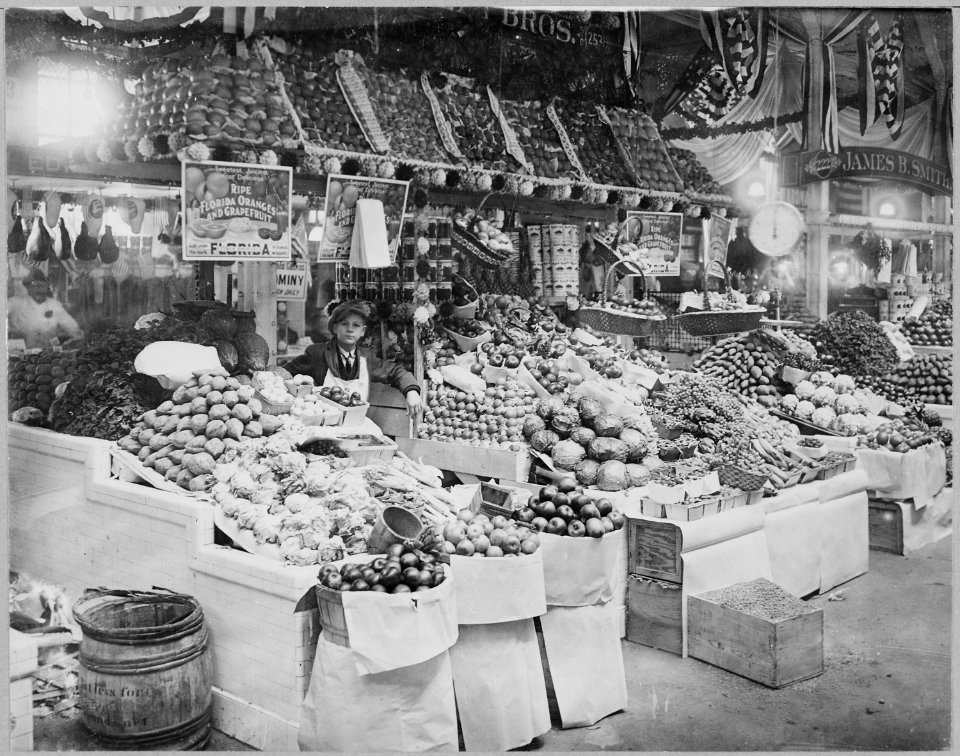 Young boy tending freshly stocked fruit and vegetable stand at Center Market, 02-18-1915 - NARA - 521049