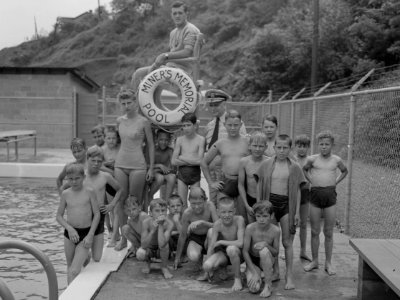 “MINER’S MEMORIAL POOL - ”Rear Admiral Joel T. Boone with group of miner's children at swimming pool which was constructed by popular... - NARA - 540301 (cropped)