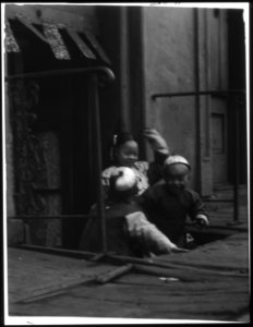 Three children in front of a cellar door, Chinatown, San Francisco LOC agc.7a55030