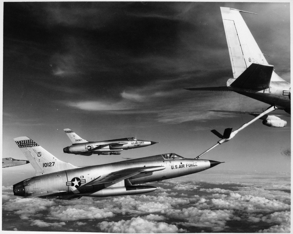 Three Air Force F-105 Thunderchief pilots enroute to bomb military target in Vietnam pull up to a flying Air Force gas - NARA - 541859