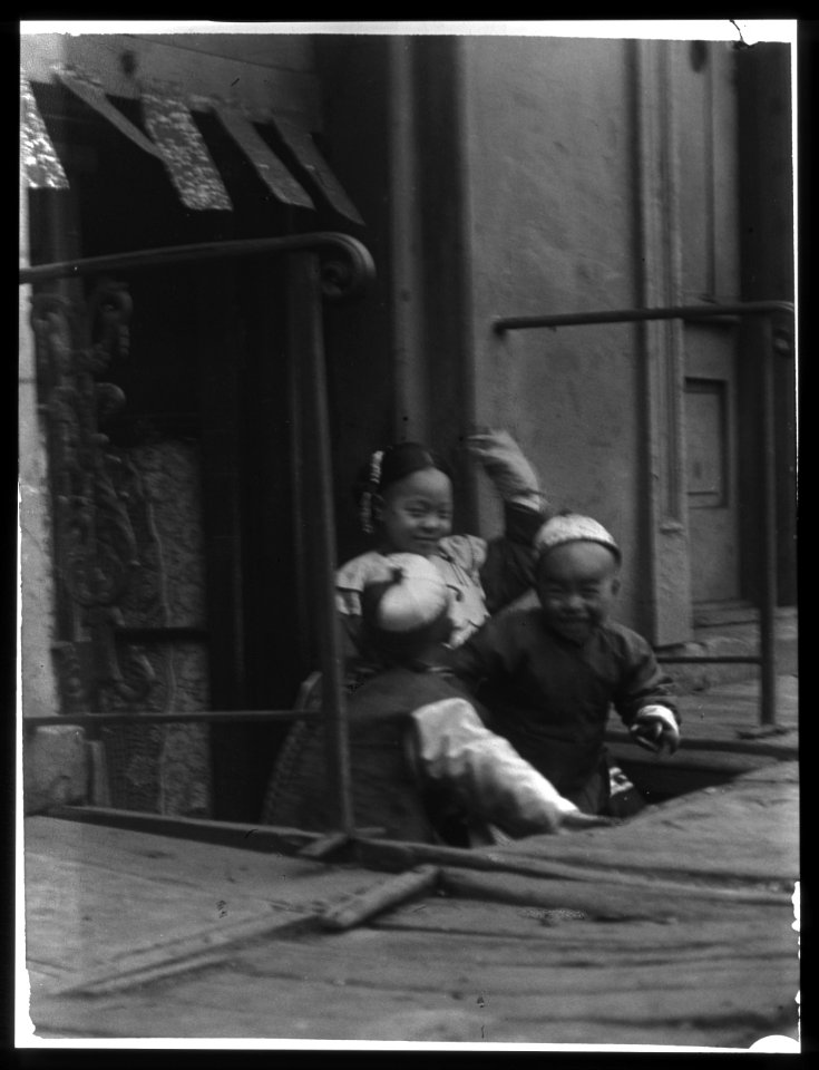Three children in front of a cellar door, Chinatown, San Francisco LOC agc.7a55031